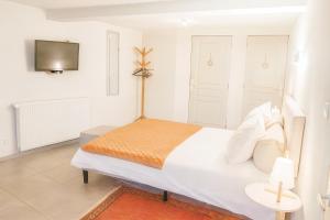 a white bedroom with a bed and a tv at Maison d'hôtes Aux Deux Cigognes in Gries +50 photos