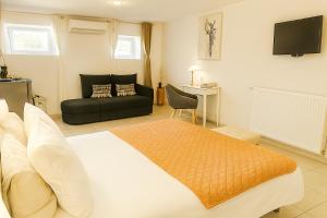 a bedroom with a large bed and a couch at Maison d'hôtes Aux Deux Cigognes in Gries