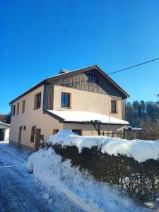 a house with snow on the ground in front of it at Ferienhaus Miriquidi Perle in Marienberg