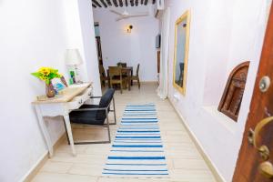 a hallway with a desk and blue and white rugs at CoastalCharms Zanzibar in Zanzibar City