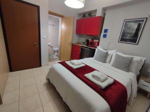 a bedroom with a large bed with towels on it at LD Studio Larissa in Larisa