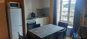 a small kitchen with a table and a refrigerator at Les hortensias studio 6 in Bourbonne-les-Bains