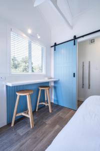 a bedroom with a blue cabinet and two stools at Small Stays at The Quarters in Turangi