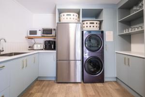 a kitchen with a washer and dryer in it at Small Stays at The Quarters in Turangi