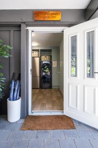 a door to a laundry room with a washer and dryer at Small Stays at The Quarters in Turangi