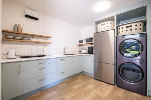 a kitchen with a refrigerator and a washer and dryer at Small Stays at The Quarters in Turangi +14 photos