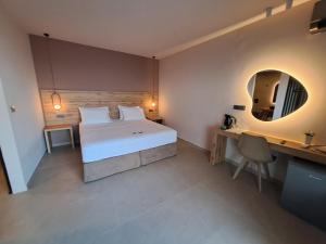 a bedroom with a bed and a desk and a mirror at Castella Luxe in Loutro +9 photos