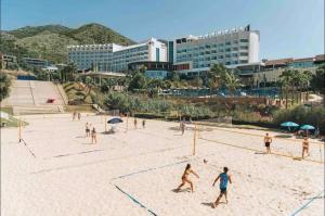 a group of people playing volleyball on a beach at higuerón Aqualis in Torremuelle