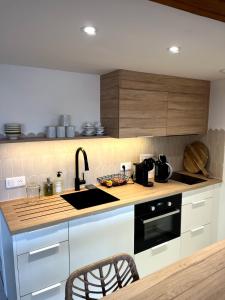 a kitchen with a sink and a stove top oven at Le Citrus - Séjour cosy en plein centre historique in Montaigu-Vendée