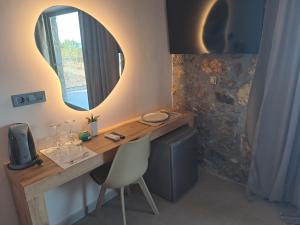 a desk with a mirror and a chair in a room at Castella Luxe in Loutro