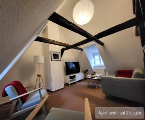 a living room with a couch and a tv at Anno 1577 - Marktkirchhof 6 in Quedlinburg