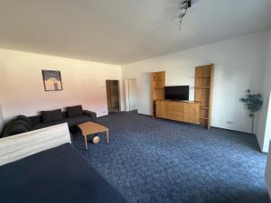 a living room with a couch and a tv at Wiehengebirgs Fernblick App 2 in Bad Essen