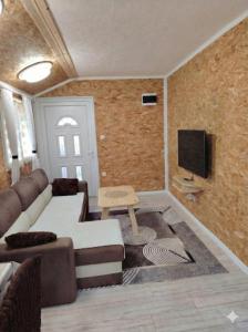 a living room with a couch and a tv at Mubina Apartman in Ćukovi