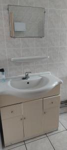 a bathroom with a white sink and a mirror at Les hortensias studio 6 in Bourbonne-les-Bains