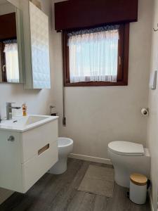 a white bathroom with a toilet and a sink at Appartamento Venezia in Marghera +20 photos