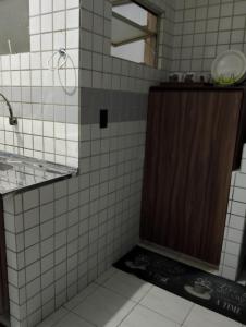 a bathroom with a shower with a brown door at Kitnet mobiliado a minutos do Parque do Povo in Campina Grande +26 photos