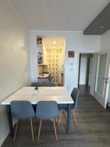 a dining room with a white table and blue chairs at Appartamento Venezia in Marghera