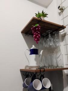 a shelf with a bunch of glasses and cups at Kitnet mobiliado a minutos do Parque do Povo in Campina Grande