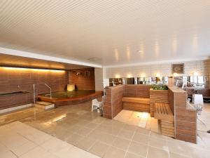 a large room with a bath tub and a table at Shiga Park Hotel in Yamanouchi