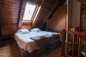 a bedroom with a bed in a room with a window at La Borda del Gato Rafa in Vielha