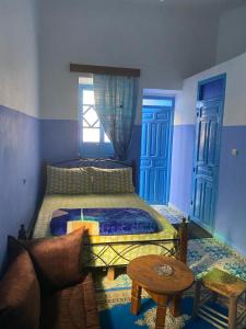 a bedroom with a bed and a couch and a table at Hotel Ahrazem in Chefchaouen