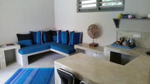 a living room with a blue couch and a table at Thalpe Bungalows in Unawatuna