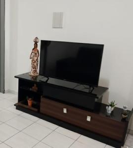 a entertainment center with a flat screen tv on it at Kitnet mobiliado a minutos do Parque do Povo in Campina Grande