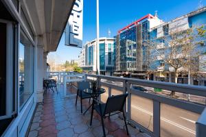 a balcony with chairs and a view of a city at Hotel Bojatours in Podgorica