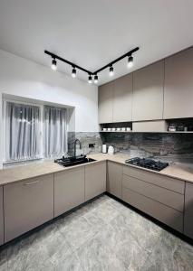 a kitchen with white cabinets and a sink at Brick House in Slavske