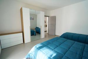 a bedroom with a blue bed and a mirror at Il Vecchio Pozzo Apartments in Ostigliano