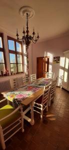 a dining room with a table with chairs and a chandelier at Les Tourelles in Contes