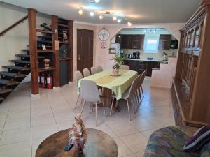 a dining room and kitchen with a table and chairs at Casa Potcovarului in Drăguş