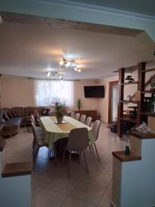 a living room with a table and chairs and a couch at Casa Potcovarului in Drăguş