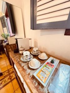 a table with plates and cups and dishes on it at Cadivó Chalé Lavras Novas in Ouro Preto