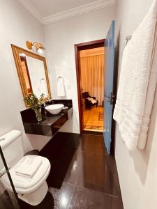 a bathroom with a toilet and a sink and a mirror at Cadivó Chalé Lavras Novas in Ouro Preto +16 photos