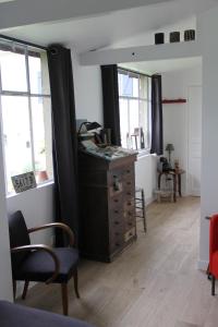 a living room with a dresser and two windows at LE Petit Ru 10 MN DE GIVERNY in Saint-Marcel