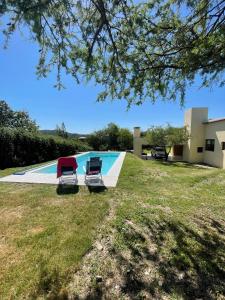 two lawn chairs sitting next to a swimming pool at La Madriguera de Potrerillo in Alta Gracia