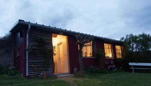 a small house with a light on the front of it at LE Petit Ru 10 MN DE GIVERNY in Saint-Marcel