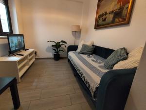 a living room with a couch and a flat screen tv at Aura Guesthouse in Lagos