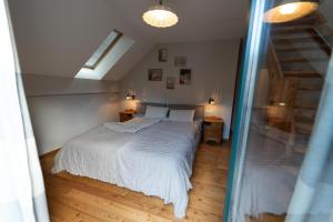 a bedroom with a white bed and a staircase at CHALET MACESEN Apartment Mauro with sauna - in the center of Kranjska gora in Kranjska Gora
