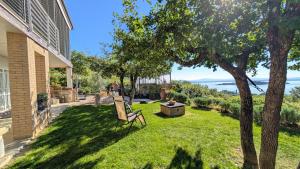 a yard with a chair and a tree at Villa Vista Lago con Jacuzzi e Campo Volley in Monte del Lago +20 photos