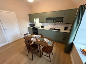 a kitchen with a table and chairs in a room at Roods Apartment in Angus