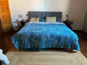 a bedroom with a bed with a blue comforter at Casa-Stella-Azores in Capelas