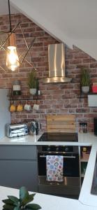 a kitchen with a stove and a brick wall at Seaside Apartment in Moreton