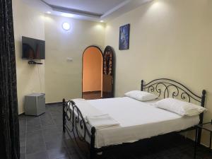 a bedroom with a large bed with white sheets at Sall Africa Tourisme in Mbour