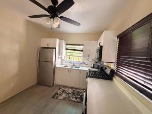 a kitchen with white cabinets and a ceiling fan at Cozy Nest in George Town