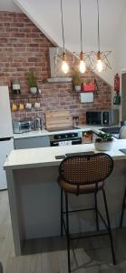 a kitchen with a counter with a chair in it at Seaside Apartment in Moreton