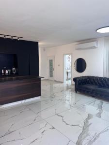 a living room with a couch on a marble floor at Boutique Penthouse by Weizmann - פנטהאוס בוטיק in Rechovot
