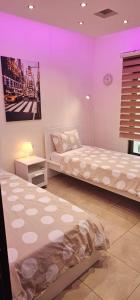 two beds in a room with purple lighting at 2 bedrooms apartment no 13 in Amman +9 photos