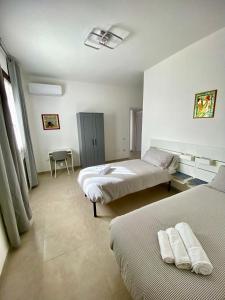 a hotel room with two beds and a chair at Rooms Domu Ajo in Monserrato